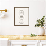 Framed minimalist print showing kitchen conversion charts for pint and quart in mason jar illustrations with neutral tones, hanging on white wall over wooden countertop and white cabinetry.