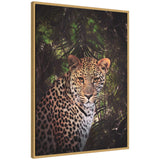 Framed canvas portrait of a leopard with detailed spotted fur set against a dark, leafy rainforest background with shafts of green light.