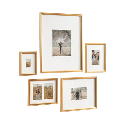 Adlynn 5 Piece Wall Picture Frame Set displayed on a wall in gold finish, showing multiple framed photos arranged cohesively.