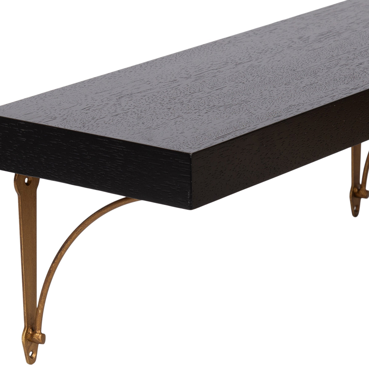 Close-up of a dark wood floating shelf with visible wood grain and curved metal gold-toned brackets securing it to the wall