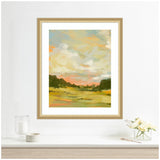 Framed landscape painting showing grassy fields and dark green trees under a sky with soft, blended clouds in blue, beige, and pink hues.