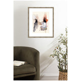 Abstract watercolor artwork with soft beige, black, and rusty red brushstrokes in a light wood frame on a white wall above an olive green armchair and woven basket plant.