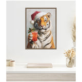 Framed canvas painting of a tiger wearing a red Santa hat, holding a festive cocktail garnished with holly berries, against a light neutral background.