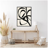 Abstract black twisted lines on white background in a black frame above a wooden console table with woven baskets, neutral decor, pampas grass, and a tripod lamp.