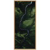 Aerial view of a winding white river cutting through a lush green valley with varying shades of green on moss-covered rocks framed in light wood.