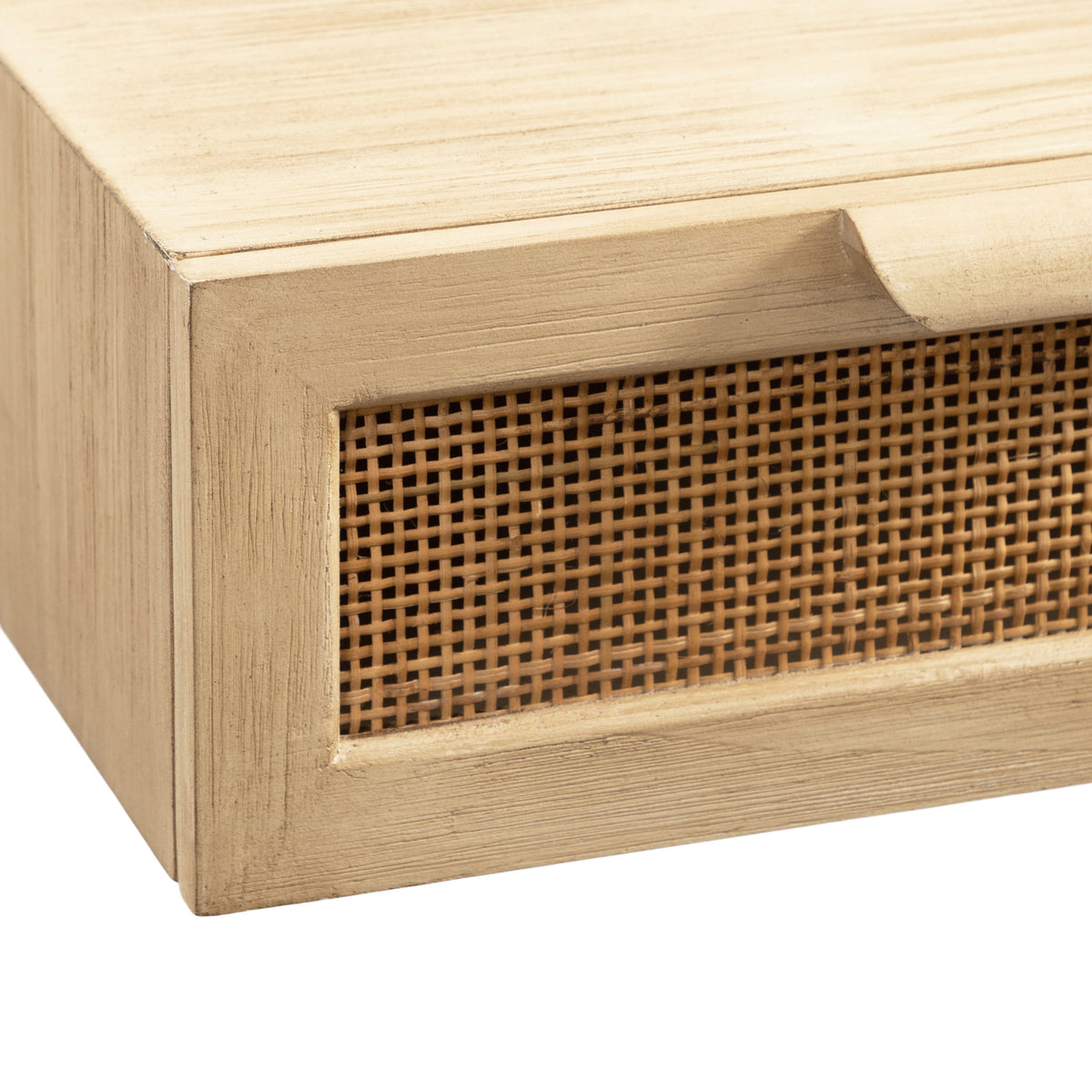 Close-up of a light wood console drawer featuring a woven rattan front panel with a small carved finger pull on the top edge.
