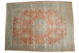 Rectangular vintage Mahal carpet with distressed coral center medallion and pale blue floral border on a muted beige background.