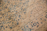 Close-up of a vintage Mahal carpet with beige background featuring blue and brown floral and geometric patterns and a distinct zigzag border design.