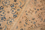 Close-up of vintage Mahal carpet showing beige base with delicate blue and brown floral and geometric patterns and a zigzag border design.