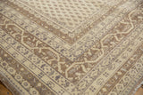 Corner of an 11x15 vintage distressed Sivas carpet featuring beige, brown, and gray geometric and floral patterns with worn texture and fringed edges.