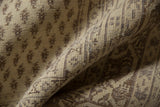 Close-up of a beige and brown vintage distressed Sivas carpet showing intricate geometric and floral patterns in a soft woven texture with visible wear.