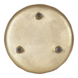 Round gold-toned decorative tray with three small black circular accents evenly spaced near the center on a smooth, slightly textured surface.