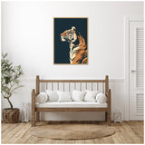 Framed canvas print of a tiger profile in warm tan and orange tones against a deep navy blue background, hanging above a wooden bench with white cushions.