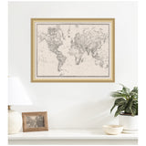 Framed vintage-style black and white world map on linen fabric hanging on a white wall above a white table with a lamp, photo frame, potted plant, and bowl.
