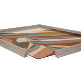 Abstract landscape art with layered geometric shapes in muted orange, beige, brown, and teal colors, shown with a light wooden frame and a cut corner.