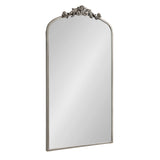 Rectangular arch-top mirror with a silver frame and ornate floral crest centered at the top, reflecting a clean, white background.