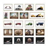 Grid of 18 framed canvas art pieces featuring vintage toy trucks, dinosaurs, and sports equipment, arranged in four rows on a white wall with light wooden frames.