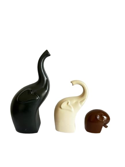 Three ceramic elephant figurines in black, brown, and off-white arranged together