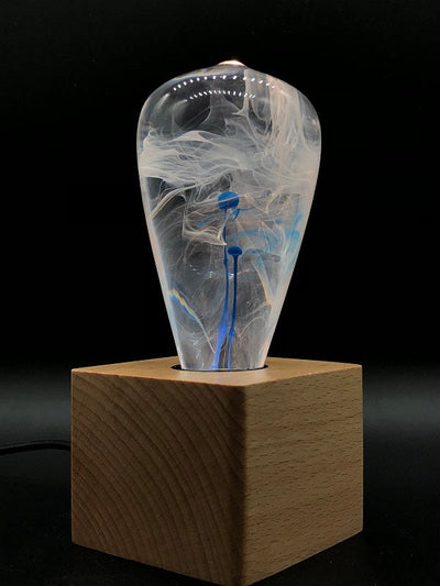 EP Light Blue-Drop Resin LED Bulb handcrafted with eco-friendly resin, shown with wooden base options