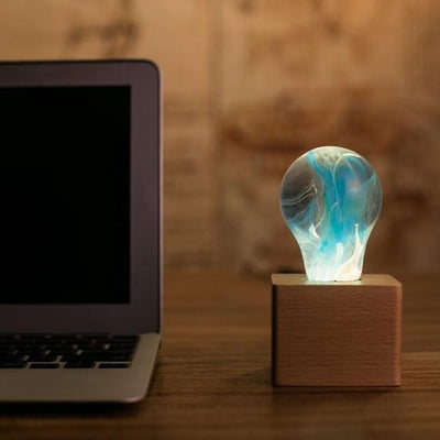 EP Light Memory Resin LED Bulb handcrafted with eco-friendly resin, shown with wooden base options
