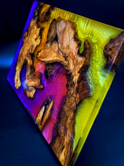 Wooden sculpture with colorful resin on a dark background