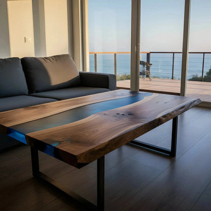 Custom walnut and blue resin epoxy coffee table on metal legs in a coastal home interior. Handmade USA furniture with marine-inspired design.