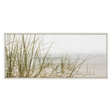 Framed canvas showing tall beach grass in soft green and beige tones with a calm sandy shore and muted ocean horizon in the background.