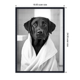 Black Labrador retriever wrapped in a white towel with a tile bathroom background, framed in a black decorative frame with labeled dimensions.