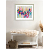 Abstract framed artwork with vibrant vertical brushstrokes in blues, pinks, oranges, and grays hangs above a white bench draped with a cream fur throw and a tan bag below.