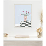 Painting of pink tulips in a pink vase on a black-and-white checkered tablecloth against a pale blue background, framed with a white and silver decorative border.