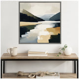 Abstract landscape painting with muted blue, beige, and black tones depicting a lake flanked by mountains, displayed above a wooden console table with books and a vase.