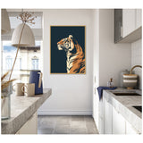 Framed canvas wall art depicting a stylized tiger profile in beige and orange on a dark navy background, hung on a white kitchen wall with granite countertops.