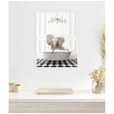 Framed canvas of a baby elephant in a gray clawfoot bathtub filled with bubbles, on black and white checkerboard floor, with a modern chandelier above.