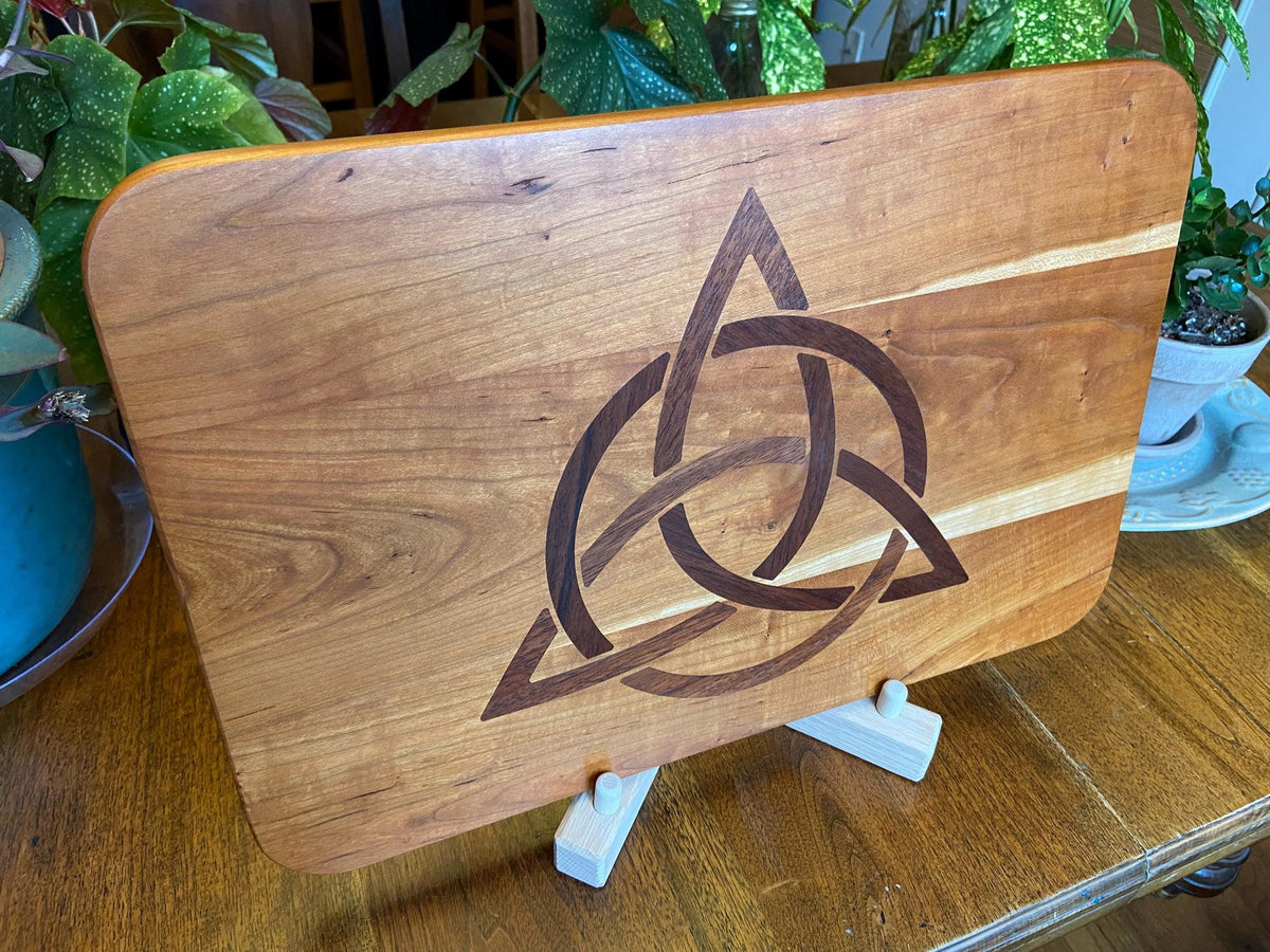 Cherry wood charcuterie board with Celtic Knot triquetra inlay made of Peruvian walnut