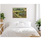 Vincent van Gogh's Garden at Arles canvas print above a white bed in a minimalist bedroom with green plants on each side, natural light from a window on the right.