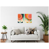Abstract framed canvas art set with concentric circular shapes in pink, orange, red, green, and teal hues above an off-white sofa with patterned pillows in a modern living room.