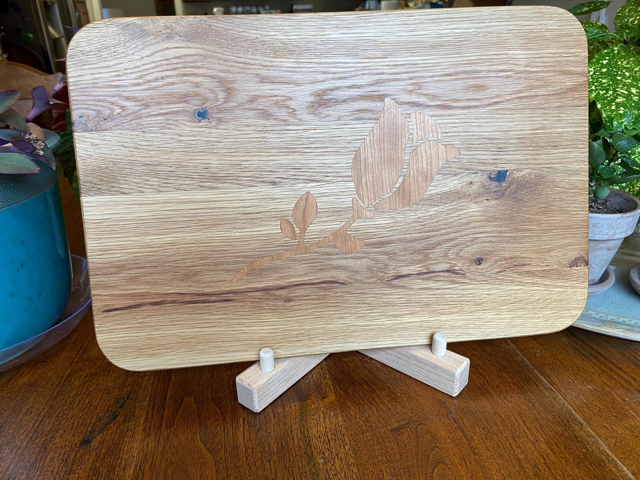 White Oak charcuterie board with subtle Cherry rose and stem inlay, handcrafted by Fitzgerald Custom Woodcraft