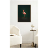 Framed wall art of a pink flamingo standing on one leg against a dark green background, hung above a metal side table with a white vase between two white upholstered chairs.