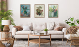 Living room with a beige sofa adorned with brown and checkered pillows, a round wooden coffee table with small decor, and three floral paintings in wooden frames above the sofa.