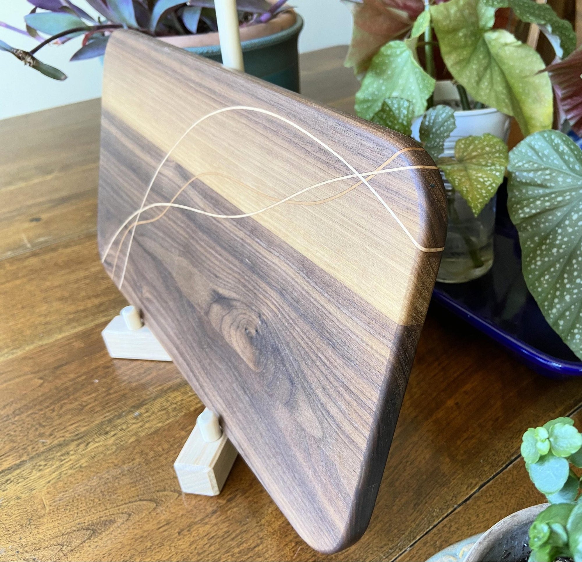 Walnut charcuterie board with cherry and maple decorative banding, handcrafted serving board