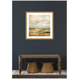 Framed abstract landscape painting with soft beige and blue tones depicting rolling hills, hung on a dark gray wall above a rustic wooden bench with two woven baskets underneath.
