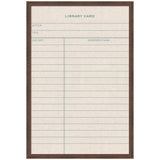 Framed linen fabric pinboard printed with a vintage-style library card design featuring author, title, due date, and borrower name fields in muted green and beige tones.