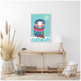 Framed colorful folk art owl with geometric patterns in blue, pink, and purple on turquoise background above wooden console table with natural decor and white lamp.