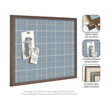 Light blue fabric pinboard with white grid lines in a dark wood frame, featuring two black-and-white photos pinned with pushpins.