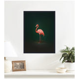 Framed canvas print of a pink flamingo standing on one leg against a rich dark green background hanging on a white wall above a white shelf with lamp, photo frame, and plants.