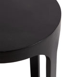 Close-up of a round black wood drink table top with smooth finish and slightly raised edge, showing part of the curved leg in shadow.