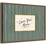 Framed canvas wall art with 'Love You More' quote in striped green background, displayed above bed in a cozy room.