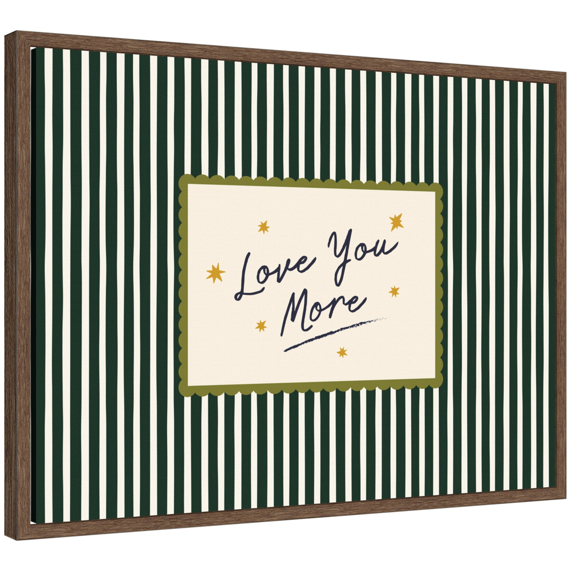 Framed canvas wall art with 'Love You More' quote in striped green background, displayed above bed in a cozy room.