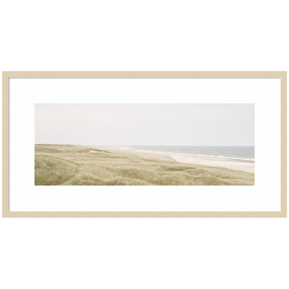 Framed coastal landscape art print showing a tranquil shoreline with boats and hills in muted colors