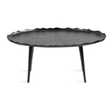 Oval black coffee table with a wavy, scalloped edge and slender, tapered legs, shown against a white background.